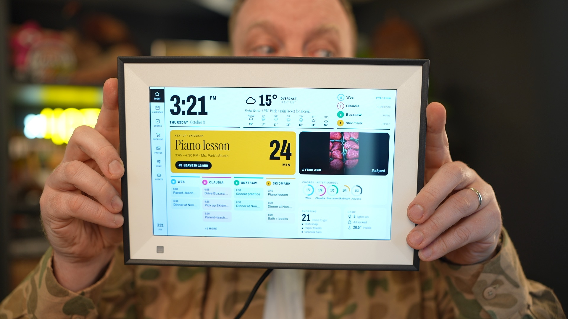 Wes Bos holding a physical photo frame displaying a family dashboard.